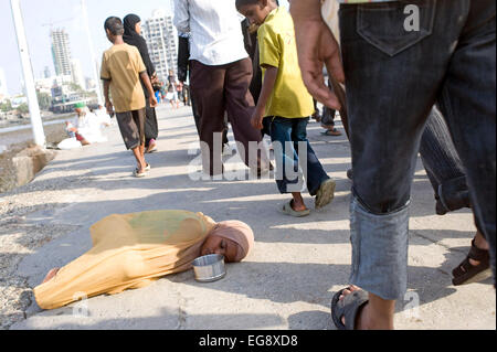 Mendicanti accumulato sulla causeway al Haji Ali moschea e Dargah , Mahalaxmi , Mumbai. Foto Stock