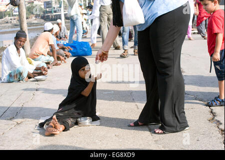 Mendicanti accumulato sulla causeway al Haji Ali moschea e Dargah , Mahalaxmi , Mumbai. Foto Stock