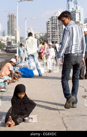 Mendicanti accumulato sulla causeway al Haji Ali moschea e Dargah , Mahalaxmi , Mumbai. Foto Stock