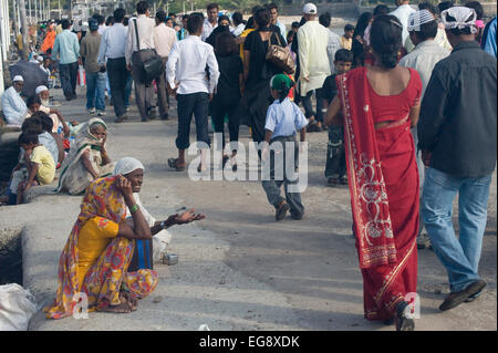 Mendicanti accumulato sulla causeway al Haji Ali moschea e Dargah , Mahalaxmi , Mumbai. Foto Stock