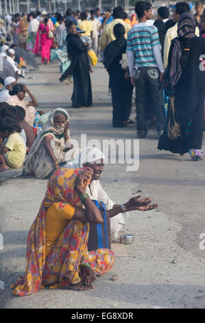 Mendicanti accumulato sulla causeway al Haji Ali moschea e Dargah , Mahalaxmi , Mumbai. Foto Stock