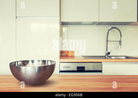 Vuoto recipiente metallico sul tavolo di legno e moderno spazio cucina. Tonica in colori caldi Foto Stock