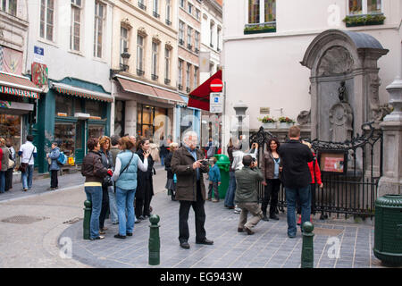 Persone provenienti da vedere la statua Manneken Pis Bruxelles Belgio Foto Stock
