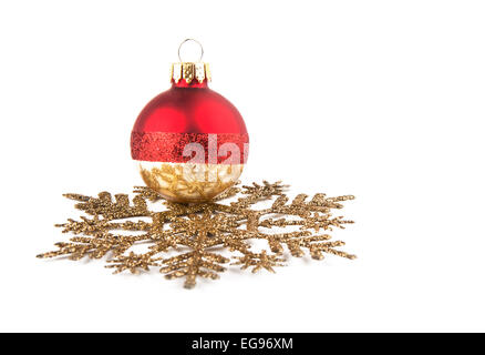 Pallina di natale in appoggio su un fiocco di neve dorata ornamento, concentrarsi sulla riflessione sulla pallina; con spazio di copia Foto Stock