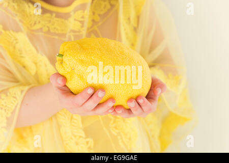 Ragazza in abito giallo azienda limone gigante