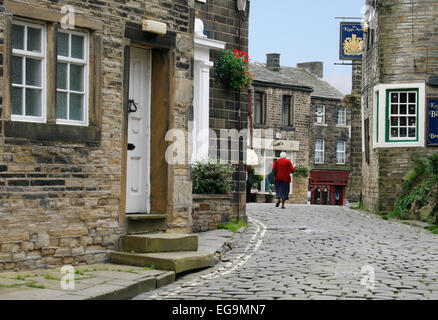 Una delle strade di ciottoli nella destinazione turistica di Haworth, West Yorkshire, molto vicino a Bronte Priory. Foto Stock