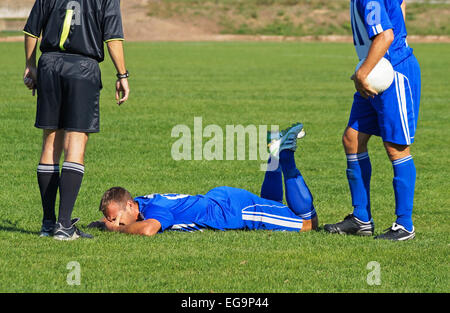 Arbitro e due giocatore di calcio Foto Stock