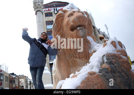 Ramallah, West Bank, Territorio palestinese. Xx Febbraio 2015. Un ragazzo palestinese gioca nella neve come egli si trova nei pressi di una statua di Lion nel centro della Cisgiordania città di Ramallah il 20 febbraio 2015. Una forte tempesta di neve ha colpito parti del Medio Oriente il venerdì, arresto di strade che conducono in e fuori di Gerusalemme e zone di irrorazione di Israele il deserto con un raro strato di bianco. La neve è scesa anche in parti della Cisgiordania, il Libano, la Giordania e la Siria come un fronte freddo ha attraversato la regione Credito: Shadi Hatem APA/images/ZUMA filo/Alamy Live News Foto Stock