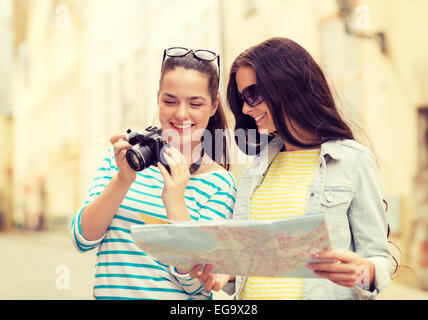 Sorridente ragazze adolescenti con mappa e fotocamera Foto Stock