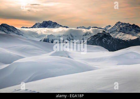 Sunset over snow covered Alpine mountains in winter in the Swiss Alps at Wallis / Valais, Switzerland Foto Stock