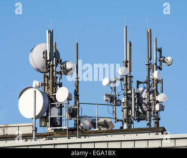 Un sacco di telcommunication antenne sul tetto di una casa Foto Stock