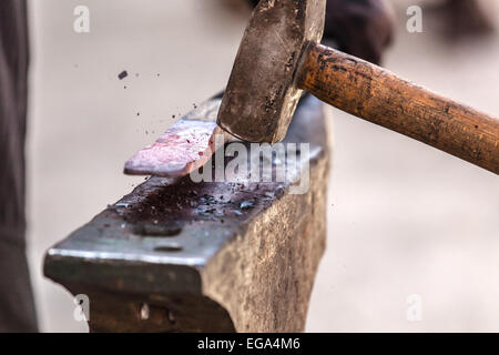 Fabbro lavora su metallo su incudine a forge dettaglio shot Foto Stock