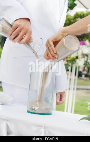 Vista ravvicinata della bella giovane coppia facendo un po' di sabbia cerimonia Foto Stock