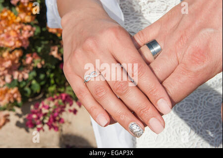 L uomo e la donna le mani insieme da sposi mostrando gli anelli di nozze Foto Stock