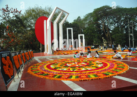 Dacca in Bangladesh. Il 21 febbraio, 2015. Giovani del Bangladesh decorano il Bangladesh Lingua centrale dei martiri monumento commemorativo con fiori in omaggio ai martiri del 1952 lingua Bengali movimento, presso l'università di Dhaka campus a Dhaka il 21 febbraio 2015. Essa segna 63 anni da quando la polizia ha sparato a migliaia di dimostranti presso una università in Bangladesh impegnativo che essere bengalese ha dichiarato lo stato di lingua. Credito: Mamunur Rashid/Alamy Live News Foto Stock