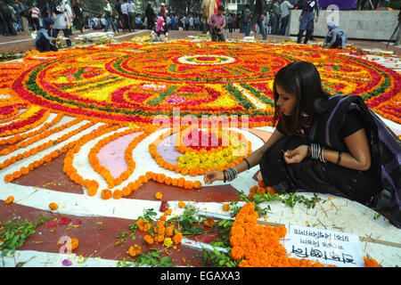 Dacca in Bangladesh. Il 21 febbraio, 2015. Giovani del Bangladesh decorano il Bangladesh Lingua centrale dei martiri monumento commemorativo con fiori in omaggio ai martiri del 1952 lingua Bengali movimento, presso l'università di Dhaka campus a Dhaka il 21 febbraio 2015. Essa segna 63 anni da quando la polizia ha sparato a migliaia di dimostranti presso una università in Bangladesh impegnativo che essere bengalese ha dichiarato lo stato di lingua. Credito: Mamunur Rashid/Alamy Live News Foto Stock