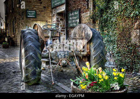 Antico trattore su un paese in ciottoli street. Foto Stock