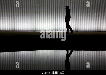 Lonely Man camminare sotto un ponte/tunnel Foto Stock