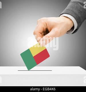 Concetto di voto - maschio inserendo bandiera in urne - Benin Foto Stock