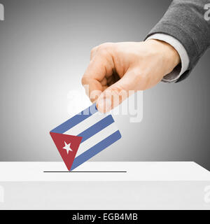 Concetto di voto - maschio inserendo bandiera in urne - Cuba Foto Stock