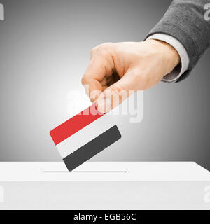 Concetto di voto - maschio inserendo bandiera in urne - Yemen Foto Stock