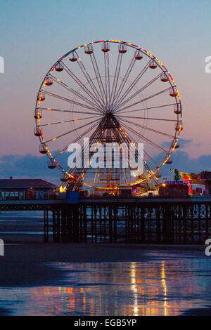 Blackpool, Lancashire, Regno Unito 21 Febbraio, 2015. Regno Unito Meteo. Tramonto sulla South Central Pier Ferris Wheel con riflessi nella sabbia bagnata. . Foto Stock