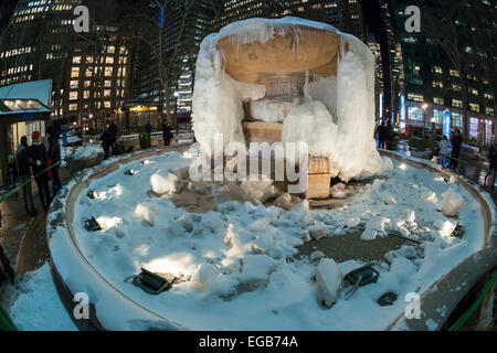 I visitatori a Bryant Park a New York stop alla Josephine Shaw Lowell Memorial Fontana che è diventato un tempo freddo sculture di ghiaccio il martedì 17 febbraio, 2015. Come la fontana è stato congelato per settimane il Bryant Park Corp. è stato costretto a rimuovere alcuni di ghiaccio per timore che il peso dei ghiaccioli danneggiare le ciotole di granito. Questo è il primo inverno che hanno avuto a che fare. (© Richard B. Levine) Foto Stock