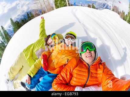 La famiglia felice la posa in presenza di neve e di rendere selfie Foto Stock