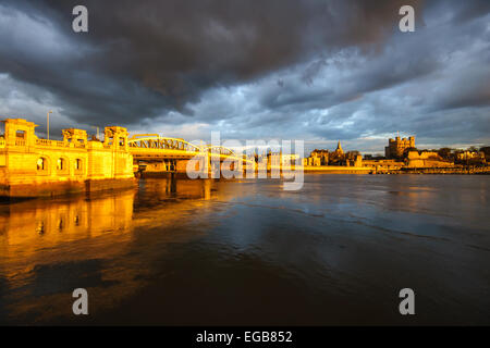 Una vista di Medway Rochester Old Bridge e Rochester Castle a stormy sera illuminata dal sole appena prima del tramonto. Foto Stock