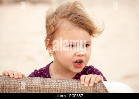 Outdoor closeup ritratto di carino bionda bambina con il vento tra i capelli Foto Stock