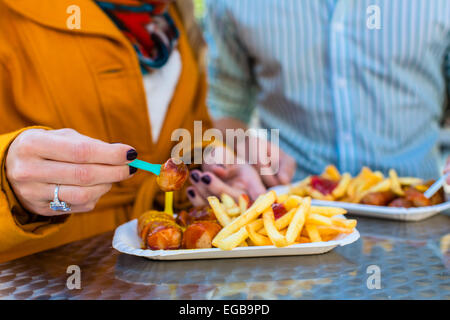 Paio mangiare tedesco Currywurst presso lo stand Foto Stock