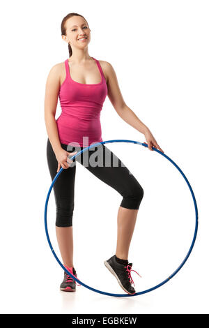 Giovane donna in piedi con hula hoop verso il basso Foto Stock