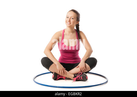 Bellezza ragazza seduta con hula hoop sul pavimento Foto Stock