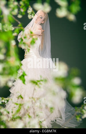 Giovane e bella sposa ha velo sul suo viso e testa. Foto Stock