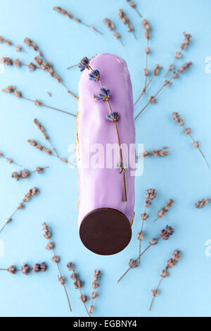 La squisita crema dessert eclair cosparso di fiori di lavanda Foto Stock