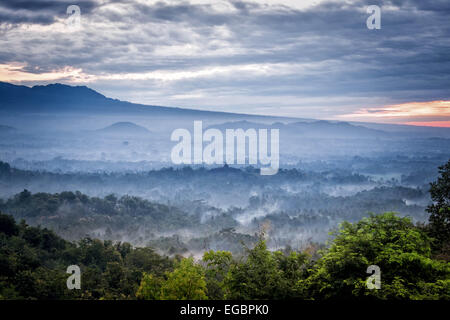 Tramonto su una valle con il Tempio Borobudur in distanza Foto Stock
