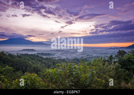 Tramonto su una valle con il Tempio Borobudur in distanza Foto Stock