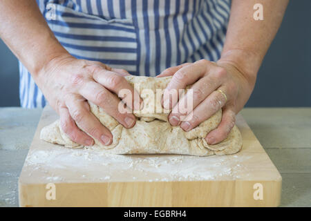 Mani femminili impastare la pasta di pane Foto Stock