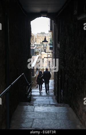 Giovane a camminare in una strada stretta a Edimburgo, Scozia Foto Stock