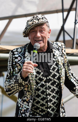 Micky driver, vestito con un gilet, giacca e cappello da re perlato, canta in un evento nostalgico all'aperto degli anni '40 con microfono portatile. Foto Stock