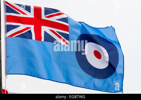 British RAF, bandiera della Royal Air Force che batte nel vento. Bandiera blu con Union Jack nell'angolo in alto a sinistra e RAF rotonda di fronte al cielo blu. Foto Stock
