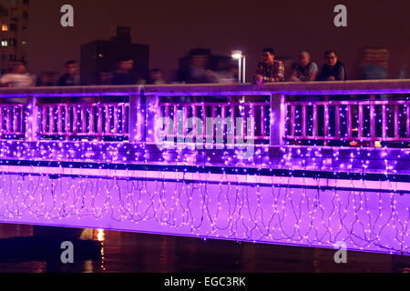 Kaohsiung, Taiwan. Il 22 febbraio, 2015. La gente che camminava sul ponte mediante il fiume dell'amore di Kaohsiung durante i festeggiamenti per il capodanno cinese. Il Capodanno cinese è un importante festival cinese ha celebrato presso la volta del calendario cinese. In Cina, è anche noto come il Festival di Primavera, la traduzione letterale del moderno nome cinese. Credito: Fabio Nodari/Alamy Live News Foto Stock