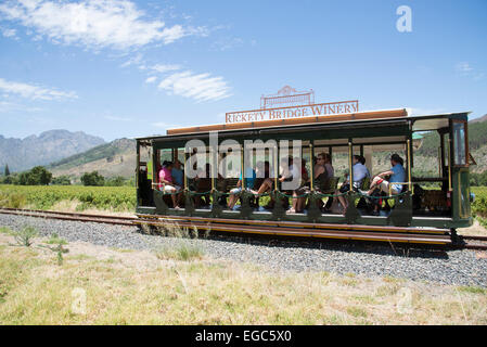 Stazione di tram per turisti attraverso vigneti a Franschhoek Western Cape Sud Africa visto qui passando per Rickey cantina a ponte Foto Stock