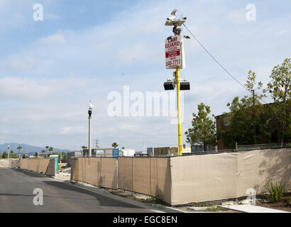 Orange County, California, Stati Uniti d'America. Il 21 febbraio, 2015. Alloggiamento di progetti di costruzione in California del sud aumenta a rampe nonostante la recessione e lunga un anno la siccità. Diversi progetti di sviluppo in Orange County, California, con migliaia di case slated per essere completato quest'anno, hanno dato l'industria della costruzione di un dosso come sede la domanda aumenta-----------una camma di protezione del sistema di protezione montato su un palo dotato di video telecamere e luci con segnali di avvertimento la sorveglianza è in corso in un cantiere in California. © David Bro/ZUMA filo/Alamy Live News Foto Stock