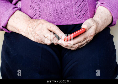 Il sambuco donna chiamando qualcuno o messaggi SMS sullo smartphone Foto Stock