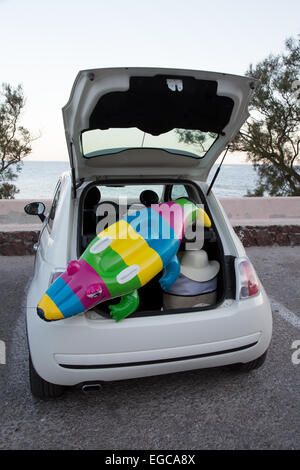 La baule auto piena di accessori da spiaggia Foto Stock