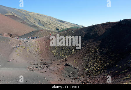 I turisti sul bordo di un cratere presso il monte Etna, Sicilia, Italia Foto Stock