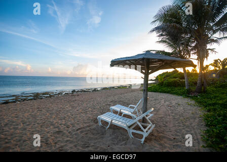 Un inizio di mattina vista di una coppia di reclino sedie a sdraio su una spiaggia cubana Foto Stock