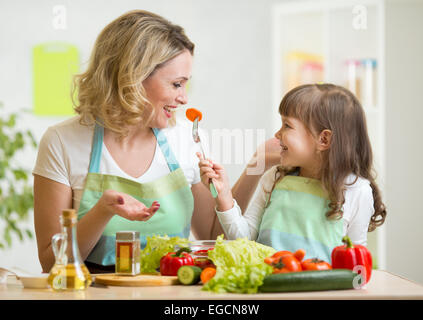 Ragazzo e una ragazza madre di mangiare cibo sano e verdure Foto Stock