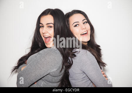 Due sorelle Pendente ritornare indietro ridendo. Foto Stock